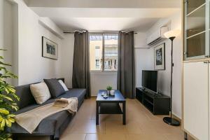 a living room with a couch and a tv at Exclusive Deluxe Apartment - Fuengirola Beachfront in Fuengirola +12 photos