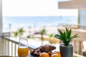 a plate of food and a glass of orange juice at Exclusive Deluxe Apartment - Fuengirola Beachfront in Fuengirola