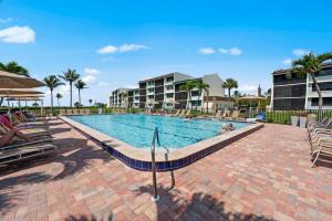萨尼贝尔Loggerhead Cay 302 W Bikes Pool On Beach!的度假村的游泳池里有人