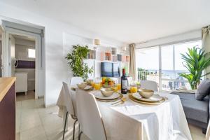 フエンヒロラにあるHigh-End Vistamar Apartment - Fuengirola Beachの白いテーブルと椅子のあるダイニングルーム