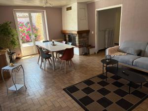 a living room with a couch and a table at Le Champ du Bonheur in Esprels