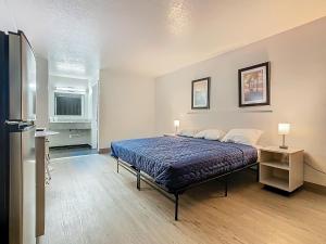 a bedroom with a bed and a desk and a refrigerator at Stayable Davenport in Davenport +55 photos