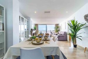 a white dining room with a table and chairs at Luxury Sea View Penthouse - Fuengirola Beach in Fuengirola