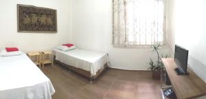 a room with a bed and a tv in it at Pousada do Parque in Porto Alegre