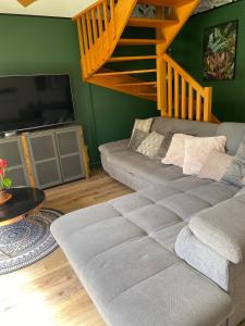 a living room with a couch and a television at Maison de vacances en résidence in Nérac