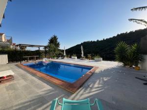 a swimming pool with two chairs next to a house at Estudio nuevo zen in Calafell