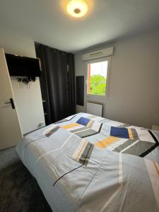 a large bed in a bedroom with a window at Maison de vacances en résidence in Nérac +24 photos