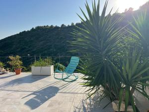 a blue chair sitting on a patio with a palm tree at Estudio nuevo zen in Calafell