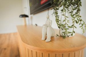a wooden table with a plant and two figurines on it at Staylight Penthouse am Französischen Garten - Zu Fuß 5 Min zur Altstadt, mit Parkplatz in Celle