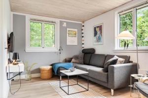 een woonkamer met een bank en twee ramen bij 1134-Ringkobing-Egernvej-12 in Nørby