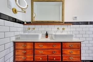 a bathroom with two sinks and a mirror at Beautiful 5 bed house, relaxing garden and driveway parking 10 min to the beach in Southend-on-Sea