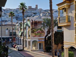 een stadsstraat met palmbomen en gebouwen bij Marfil 6 in Salobreña