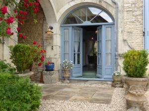 an entrance to a house with a blue door at Le Petit Souhait & Le Verger in Gourvillette