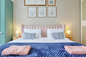 a bedroom with a bed with two pink pillows on it at Beautiful 5 bed house, relaxing garden and driveway parking 10 min to the beach in Southend-on-Sea