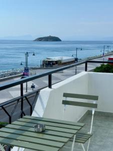 a bench sitting on a balcony overlooking the ocean at Finestra sul mare Diamante in Diamante +25 photos
