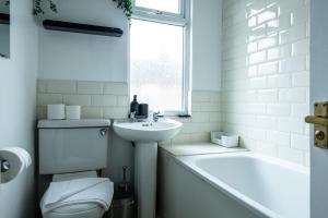 a bathroom with a toilet and a sink and a tub at 4BR Home in Great Location close to Transport in Liverpool