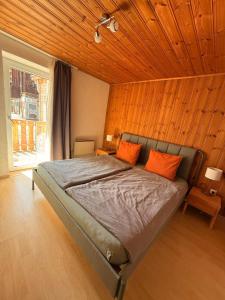 a bedroom with a bed with orange pillows on it at Ferienwohnung mit Kamin und Balkon in Samnaun