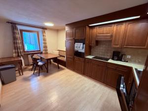 a kitchen with wooden cabinets and a table and a dining room at Ferienwohnung mit Kamin und Balkon in Samnaun