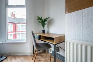 a desk and a chair in a room with a window at 4BR Home in Great Location close to Transport in Liverpool