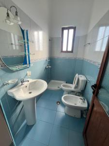 un bagno con due lavandini, un water e uno specchio di Guesthouse Fatos Biti a Divjakë Altre 37 foto