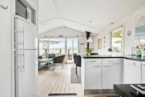 een keuken met witte kasten en een eetkamer bij 235-Ringkobing-Vestklitvej-11 in Klegod +25 foto's
