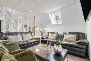 un soggiorno con divani in pelle nera e un tavolo di 1106-ringkobing-Klitrosevej-4 a Nørby