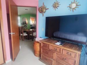 a living room with a television on a wooden dresser at Rincón de Checo in Mexico City