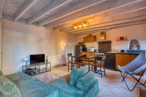 Maison 3 pièces , terrasse LA BOUQUERIE في سارلا لا كانيدا: غرفة معيشة مع أريكة ومطبخ