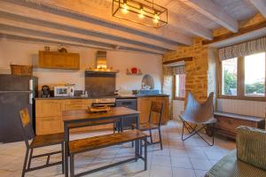 Maison 3 pièces , terrasse LA BOUQUERIE في سارلا لا كانيدا: مطبخ مع طاولة وكراسي في الغرفة +8 صور