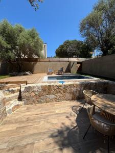 a patio with a table and chairs and a pool at Aria Linda in Belgodère