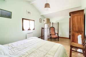 a bedroom with a bed and a chair at Maison de campagne - maeva home - Maison 4 pièces 6 personnes - Confort MAE-7261 in Carcans
