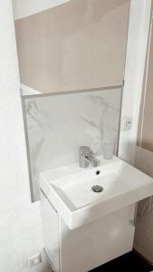 Un baño blanco con lavabo y espejo. en Haus Leipheim, en Leipheim