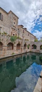 a building with a pool of water in front of it at Merlo House Dol Hvar in Stari Grad