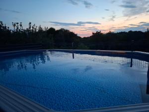 a large swimming pool with a sunset in the background at Kuća za odmor Vila Valentina in Škriljevec +14 photos