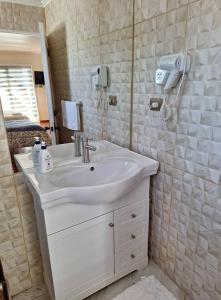 a bathroom with a white sink and a mirror at Hostal Casa Amarilla San Vicente de Tagua Tagua in San Vicente de Taguatagua