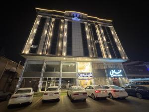 a building with cars parked in a parking lot at شقق شيل دون للشقق المخدومة in Muhayil