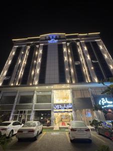 a building with cars parked in front of it at night at شقق شيل دون للشقق المخدومة in Muhayil +2 photos