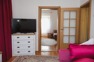 a living room with a tv on a dresser at Apartman ODISEJ in Čapljina