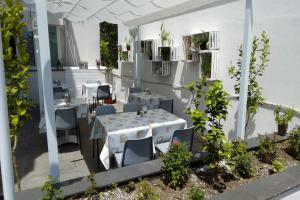 a restaurant with white tables and chairs and plants at B&B Sweet Home Two Steps From The Ruins... in Pompei