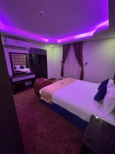 a hotel room with two beds and a purple lighting at شقق شيل دون للشقق المخدومة in Muhayil