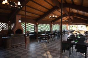 a restaurant with tables and chairs and a fireplace at Pensiunea Adonis in Arefu