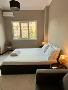 a bedroom with a bed and a window and a couch at Plaza Vista in Kalamata