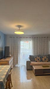 a living room with a couch and a television at Beach Apartment with Ocean View La Arena in Puerto de Santiago