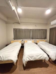 a group of three beds in a room at Wasabi Mita Hotel - Vacation STAY 84702v in Tokyo
