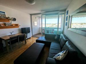 a living room with a couch and a table with a view at Marina View Apartment Izola in Izola