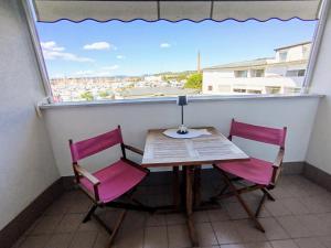 a table and two chairs on a balcony with a window at Marina View Apartment Izola in Izola +17 photos
