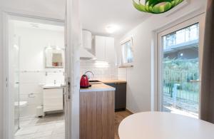a white kitchen with a sink and a counter at Wojtek - domki letniskowe i pokoje, animacje, melex na plażę in Dziwnów +124 photos