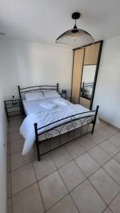 ein Schlafzimmer mit einem Bett mit einem großen Spiegel in der Unterkunft Maison Quartier du Phare in La Tranche-sur-Mer