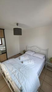 ein großes weißes Bett in einem weißen Zimmer in der Unterkunft Maison Quartier du Phare in La Tranche-sur-Mer