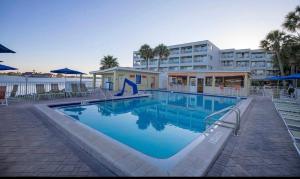 a large swimming pool in front of a hotel at This could be your view every night of your stay!! Cozy, comfy remodeled condo! in Tampa